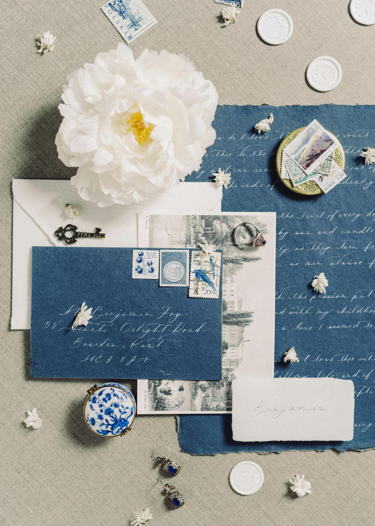 Flat-lay wedding planning essentials, featuring an elegant wedding invitation, rings, and delicate floral accents for a Los Angeles wedding with Archbride