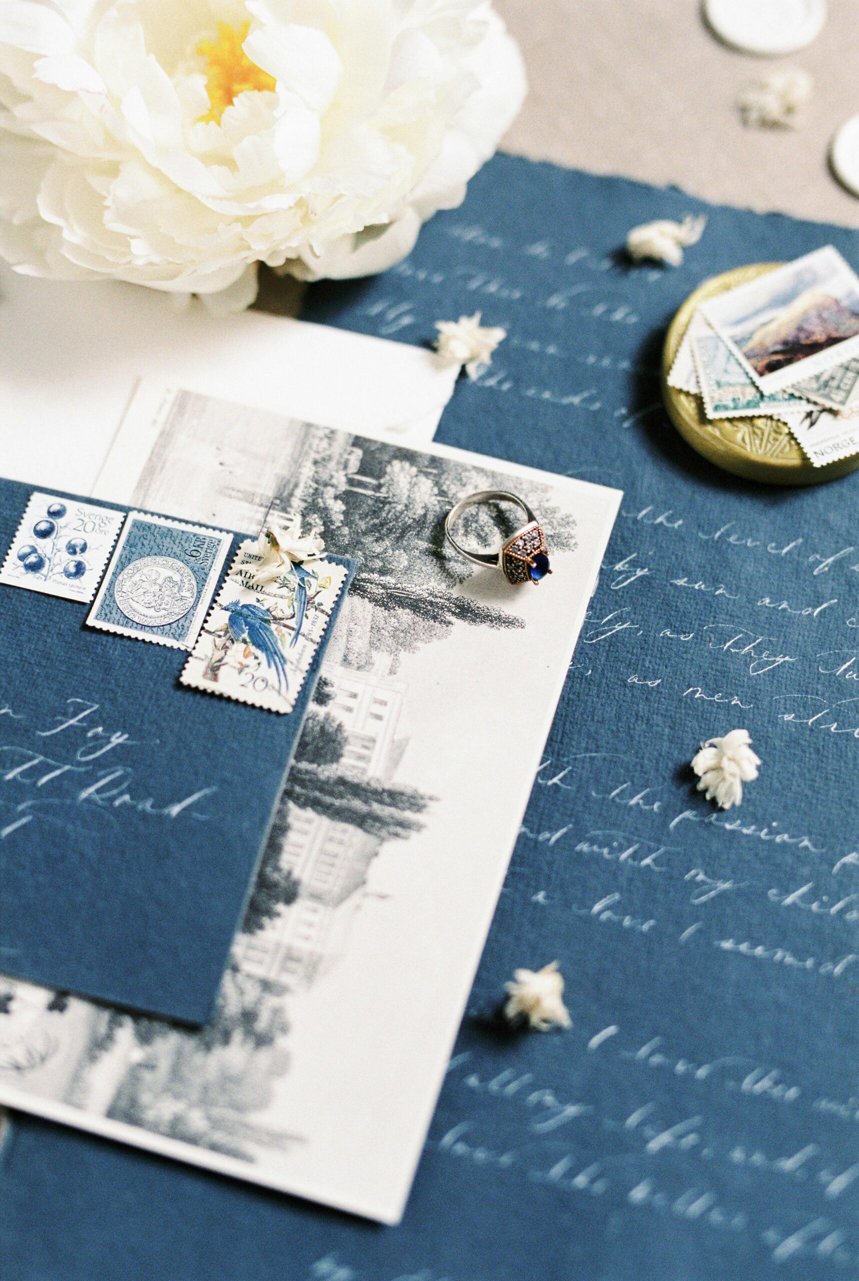 lat-lay wedding planning essentials by Archbride, featuring an elegant wedding invitation, rings, and floral accents in Los Angeles.